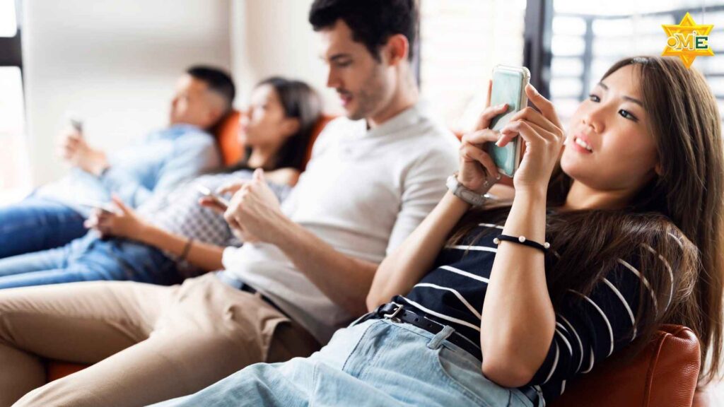 nhóm bạn trẻ ngồi cùng nhau nhưng chỉ nhìn vào điện thoại, thiếu sự kết nối thực trong đời sống